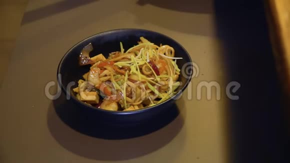 厨师将绿豆和芝麻加入米索汤的油炸配料中放入碗中视频的预览图