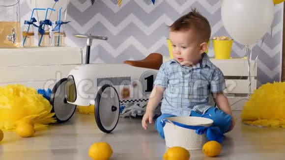 一个金发小男孩在篮子里收集柠檬视频的预览图