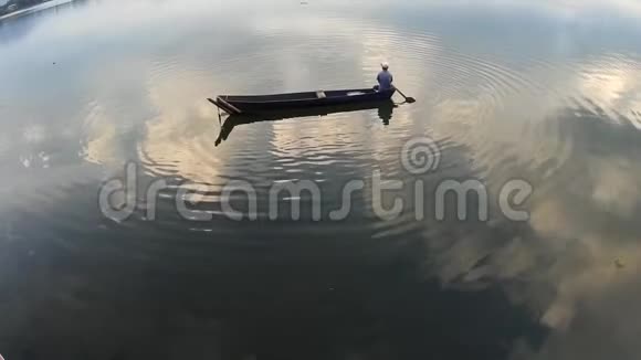 下午一个人在湖面上划着他的木船轮廓视频的预览图