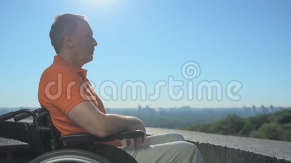 坐在轮椅上欣赏城市美景的好男人视频的预览图