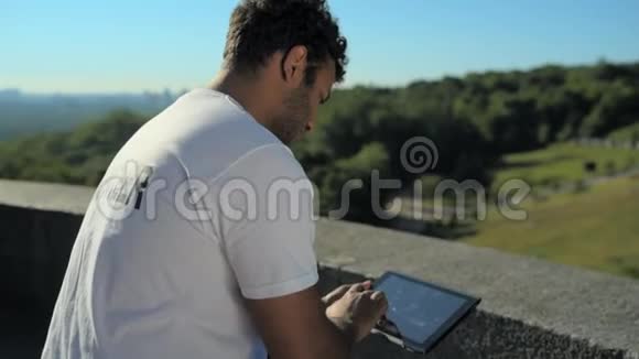 不错的男志愿者坐在户外拿着平板电脑视频的预览图