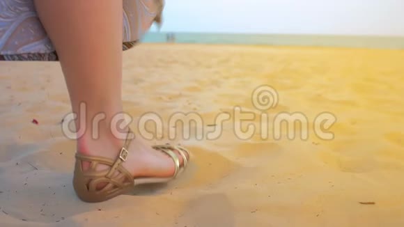 一个年轻女孩的腿站在海滩上特写镜头慢动作视频的预览图