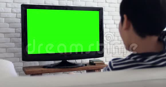 亚洲儿童在电视上玩绿色屏幕的电脑游戏视频的预览图