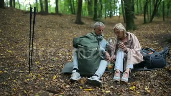 积极的老年夫妇在森林里享用他们的旅游午餐视频的预览图