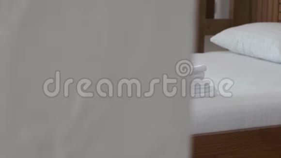 一套白色毛巾和毯子躺在旅馆房间里舒适的床上视频的预览图