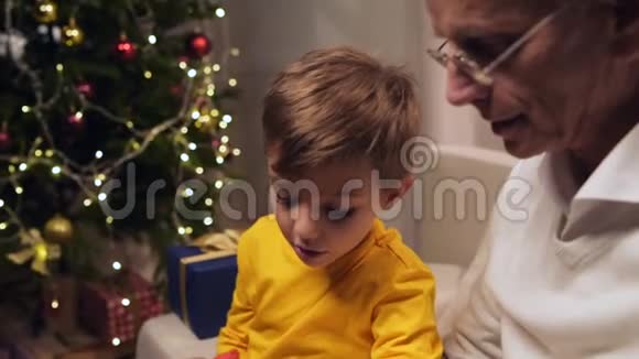 积极的老人和孙子在圣诞卡上签名视频的预览图
