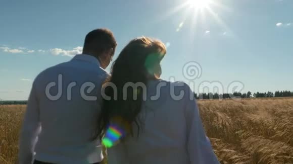 一男一女穿着白色西装带着麦子沿着田野走着慢动作视频的预览图