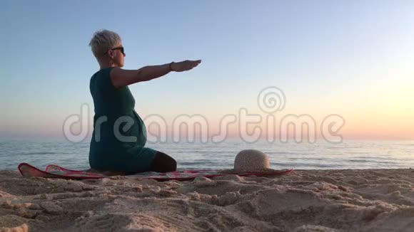 怀孕九个月的妇女在海滩上锻炼视频的预览图