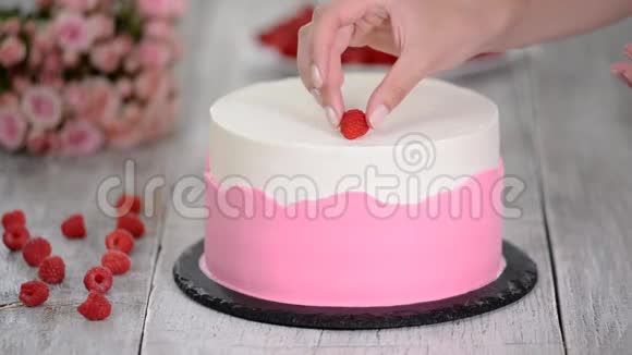 厨房的糕点厨师用覆盆子装饰蛋糕视频的预览图