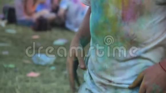 滑稽男子在霍利节上从t恤上抖出五颜六色的粉末跳舞的男子视频的预览图