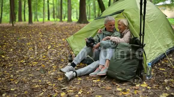 欢乐的老年夫妇在树林里用他们的照相机视频的预览图