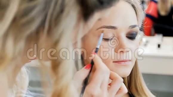 专业化妆师在视觉工作室与模特合作的特写慢动作视频女性化妆品视频的预览图