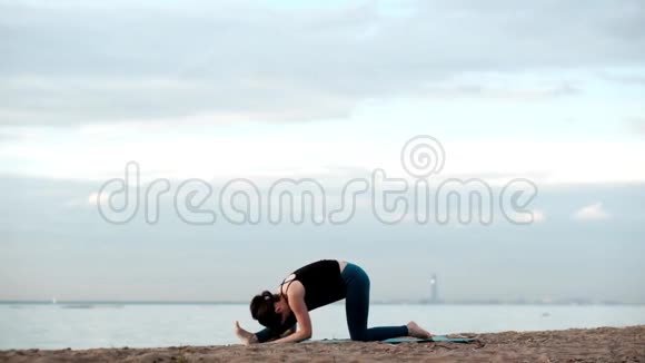 白种人瘦漂亮的女人在海滩上瑜伽视频的预览图