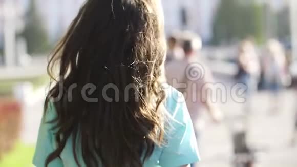 那个女孩正沿着街道走她的头发在飞舞视频的预览图