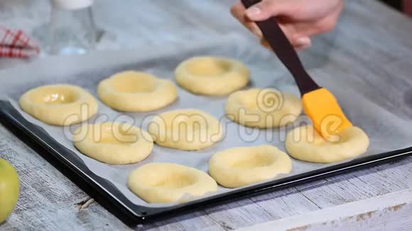 准备一个自制的开放面包Vatrushka新鲜糕点用鸡蛋给面包涂上油脂视频的预览图