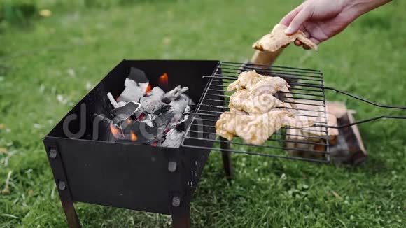厨师在户外烤架的热煤上用鸡翅做烧烤在后院烧烤视频的预览图