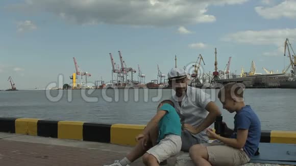 上尉和他的儿子坐在码头上视频的预览图