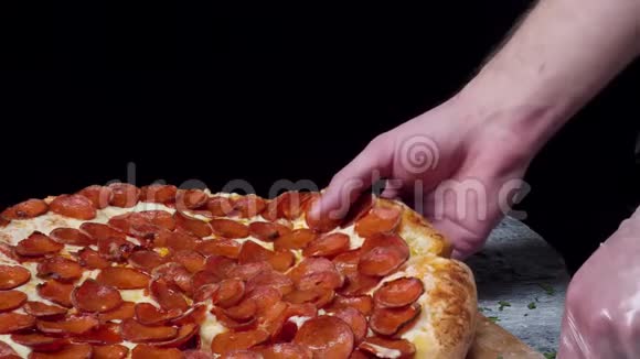 人们手拿切片披萨的特写框架吃一片带奶酪西红柿和火腿的披萨视频的预览图