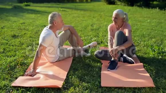 快乐的运动型老年夫妇在体育活动后休息视频的预览图