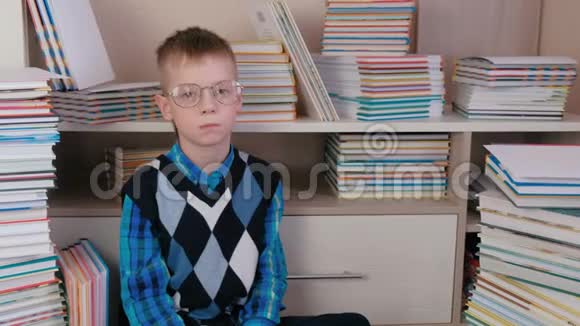 疲惫的七岁男孩戴着眼镜坐在地板上看书视频的预览图