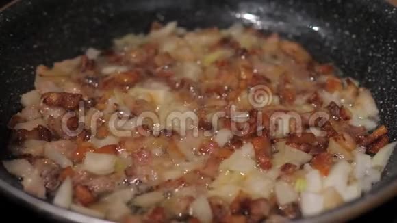 煎锅里的洋葱和培根煮油和脂肪做晚餐视频的预览图