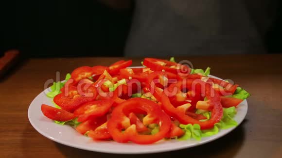 女性手把牛油果切片放在沙拉和胡椒的盘子里视频的预览图