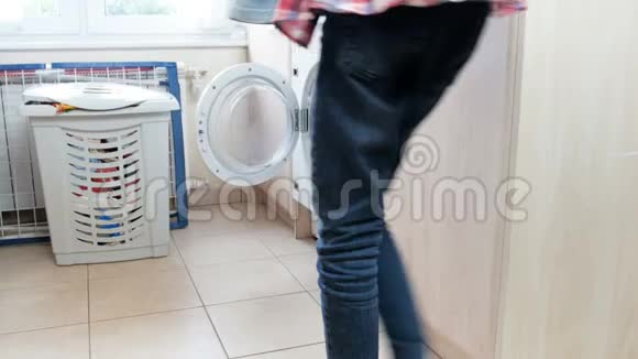 4k镜头少女在洗衣机里装衣服并打开视频的预览图