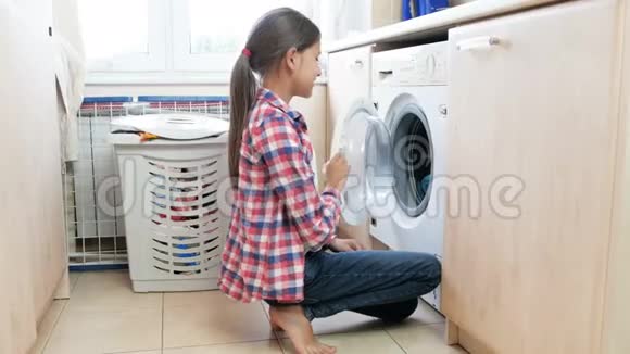4k段少女在洗衣间从洗衣机里拿出干净衣服的镜头视频的预览图