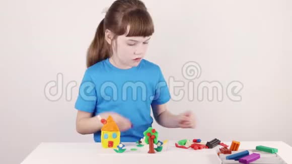 女孩在蓝色模具屋从塑料在白色桌子上白色房间的时间流逝视频的预览图