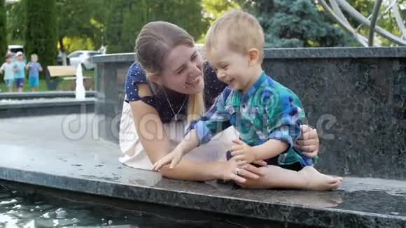 乐笑家庭在公园玩喷泉泼水的慢动作视频视频的预览图