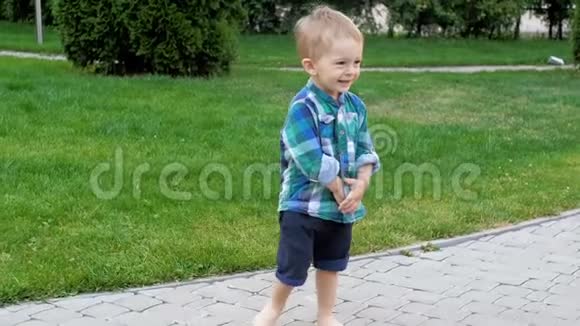 快乐微笑的幼儿男孩在公园的小路上散步视频的预览图