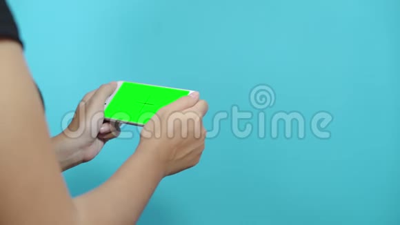 使用蓝底绿屏智能手机的女性女性手滚动页面轻触触摸屏视频的预览图