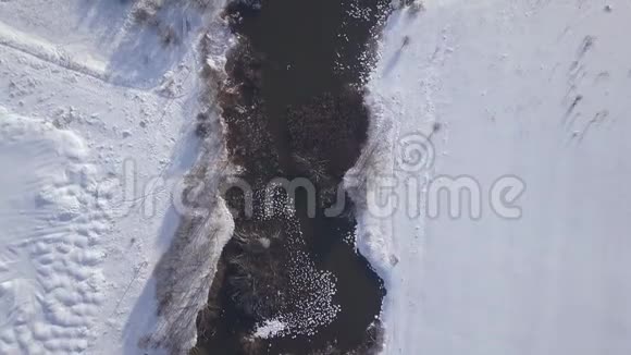 冬天的河流和岸上的白雪空中景观冬季景观冻水在河流和雪无人驾驶飞机的视野视频的预览图