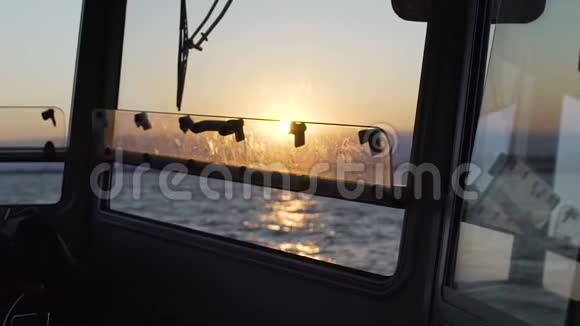 汽艇在海浪中摇曳美丽的日落在地平线上从船舱可以看到视频的预览图