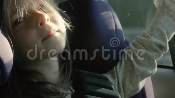 漂亮的女孩坐在车里把手伸出窗外她看起来很放松视频的预览图