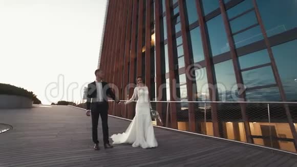 新婚夫妇走在摩天大楼附近视频的预览图