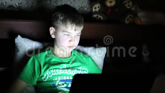 小男孩晚上在电脑上工作视频的预览图
