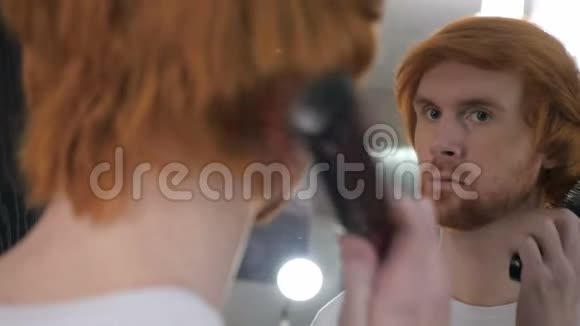 红发胡子男在镜中梳头视频的预览图