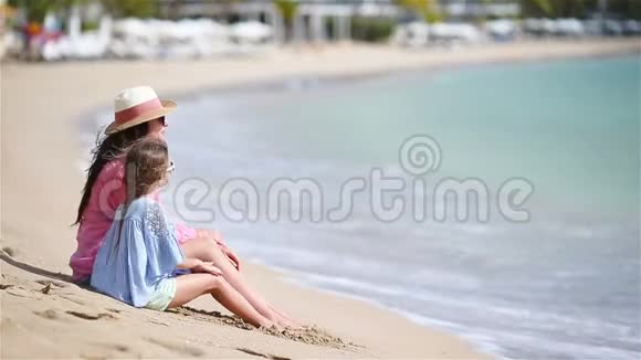 一家人在白色的海滩上欣赏海景一家人坐在沙滩上放松视频的预览图