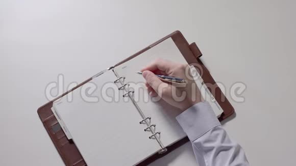 男人正在准备在笔记本上写笔记0104部分视频的预览图