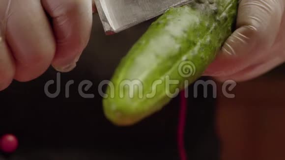 手套里的厨师拿着黄瓜切下来视频的预览图