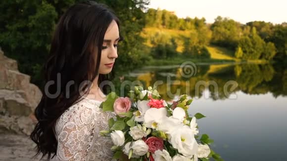 手捧花的年轻新娘看着镜头微笑特写镜头视频的预览图