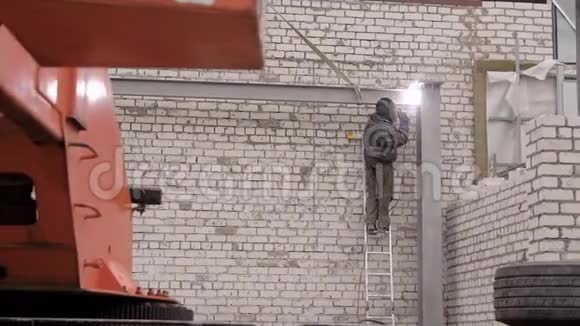 一名穿着防护制服的专业工人从事建筑物体的焊接工作其背景是视频的预览图