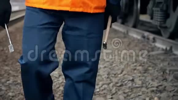 穿橙色工作服的工人在火车车厢附近行走视频的预览图