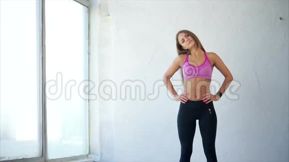 颈部热身穿着运动服做伸展运动的漂亮运动女人视频的预览图
