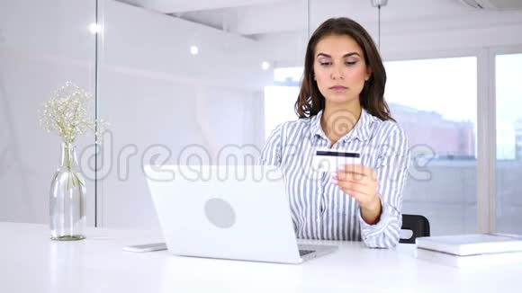 严肃的女人在网上买笔记本电脑付款视频的预览图