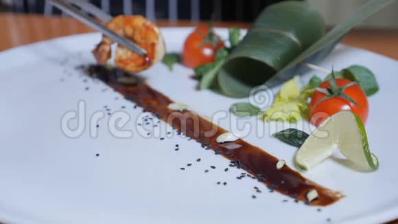 一个厨师的特写在一个盘子里放着佛兰贝风格的老虎虾慢动作石油和酒精明火视频的预览图