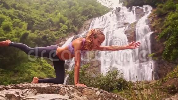 女孩在丛林里用泡沫瀑布做瑜伽姿势视频的预览图