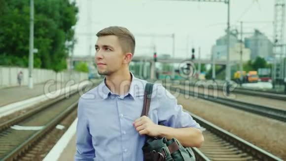 一个成功的年轻人沿着火车站步行出差抵达旅游视频的预览图