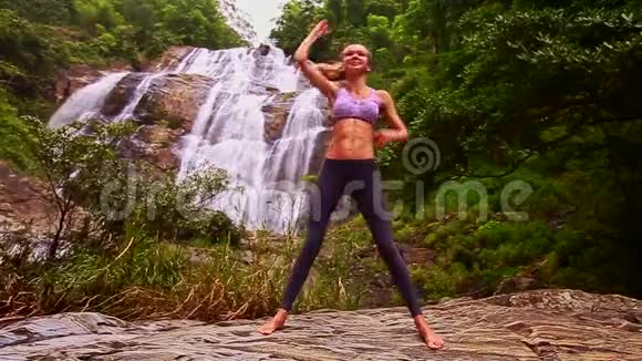 金发女孩在瑜伽姿势中弯曲身体瀑布视频的预览图